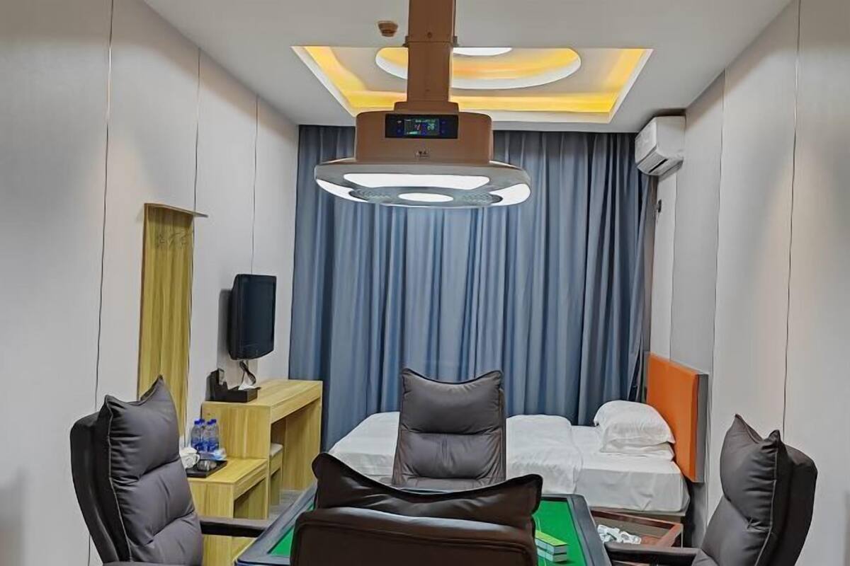 Une chambre d’hôtel comprenant un lit, un bureau avec une chaise, une télévision et un luminaire au plafond.