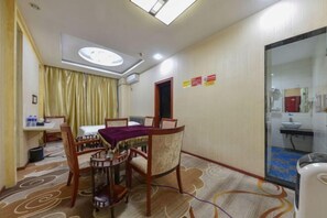 Ein Hotelzimmer mit Essbereich, einem Bett, einem Badezimmer und Blick nach draußen.