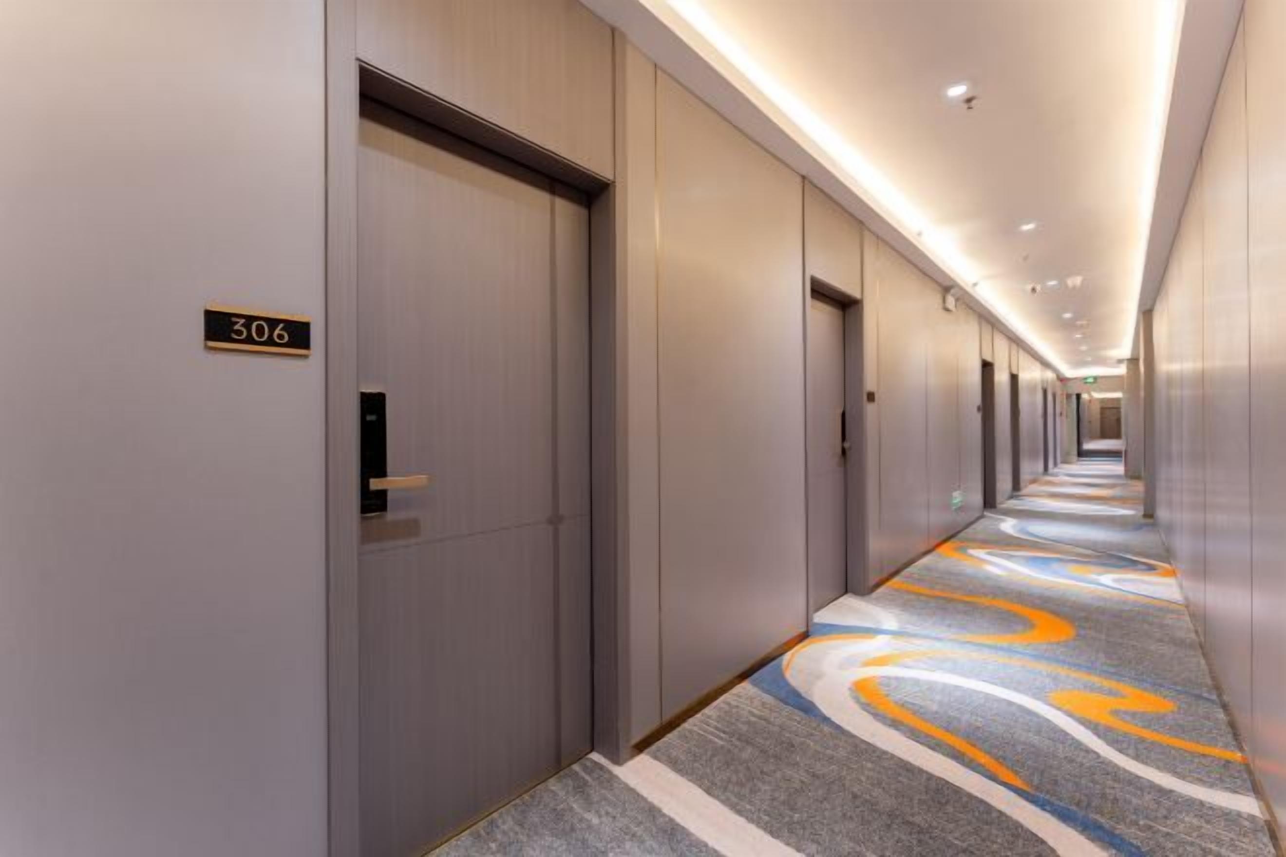 A hotel hallway with doors numbered 306, featuring a carpet with a geometric pattern.