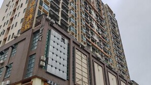 Um edifício alto com várias varandas e um grande vitrine.