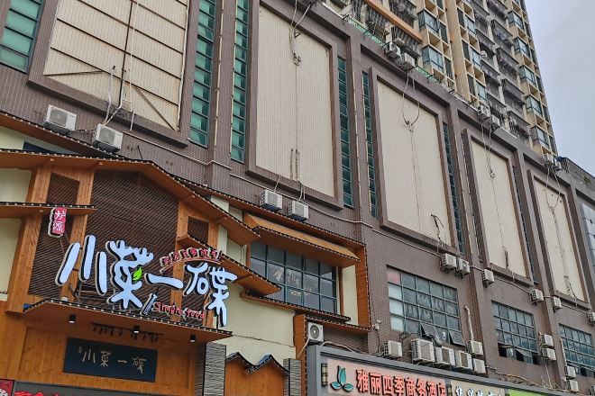 A multi-story building with signage for a restaurant and a shop.