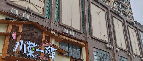 A multi-story building with signage for a restaurant and a shop.