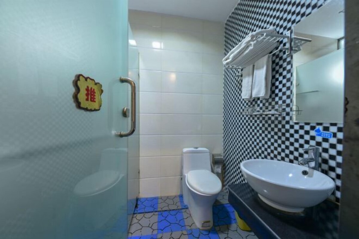 Ein Badezimmer mit Toilette, Waschbecken und einem Schachbrettmuster an der Wand.
