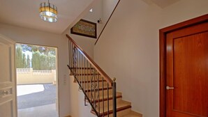Eine Treppe mit Holzbalken und schwarzen Geländern, die zu einer Holztür führt.
