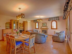 A spacious living area with a dining table, chairs, sofas, and a fireplace. - Vacation home Jardin by Interhome (Calpe/Calp)