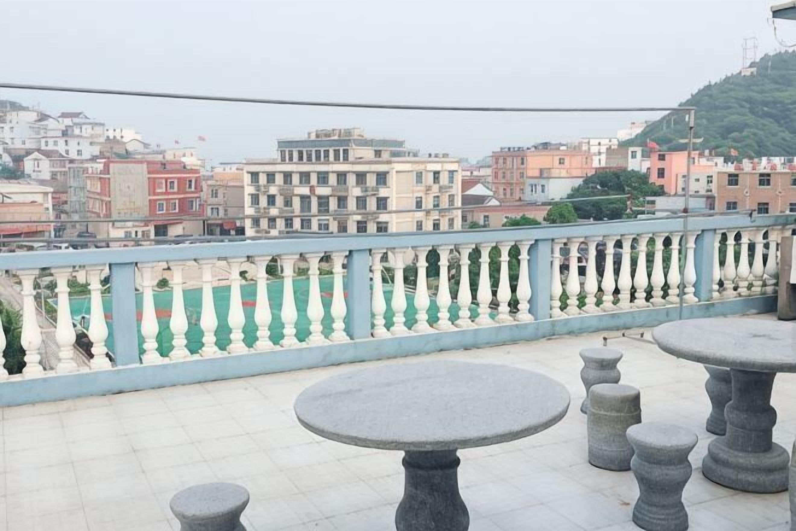 A balcony with a railing, a table, and a chair.