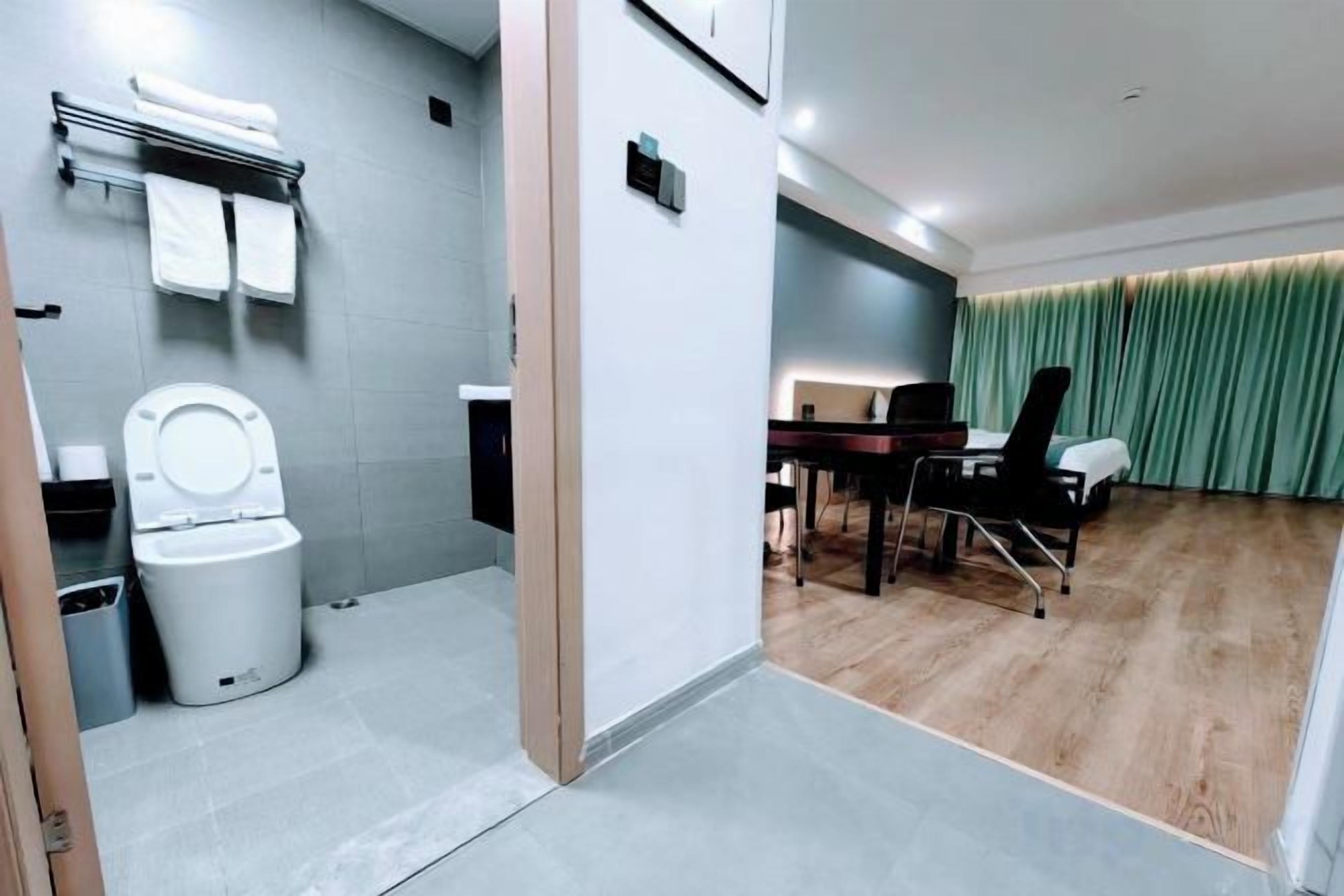 A modern bathroom with a toilet, sink, and towel rack.