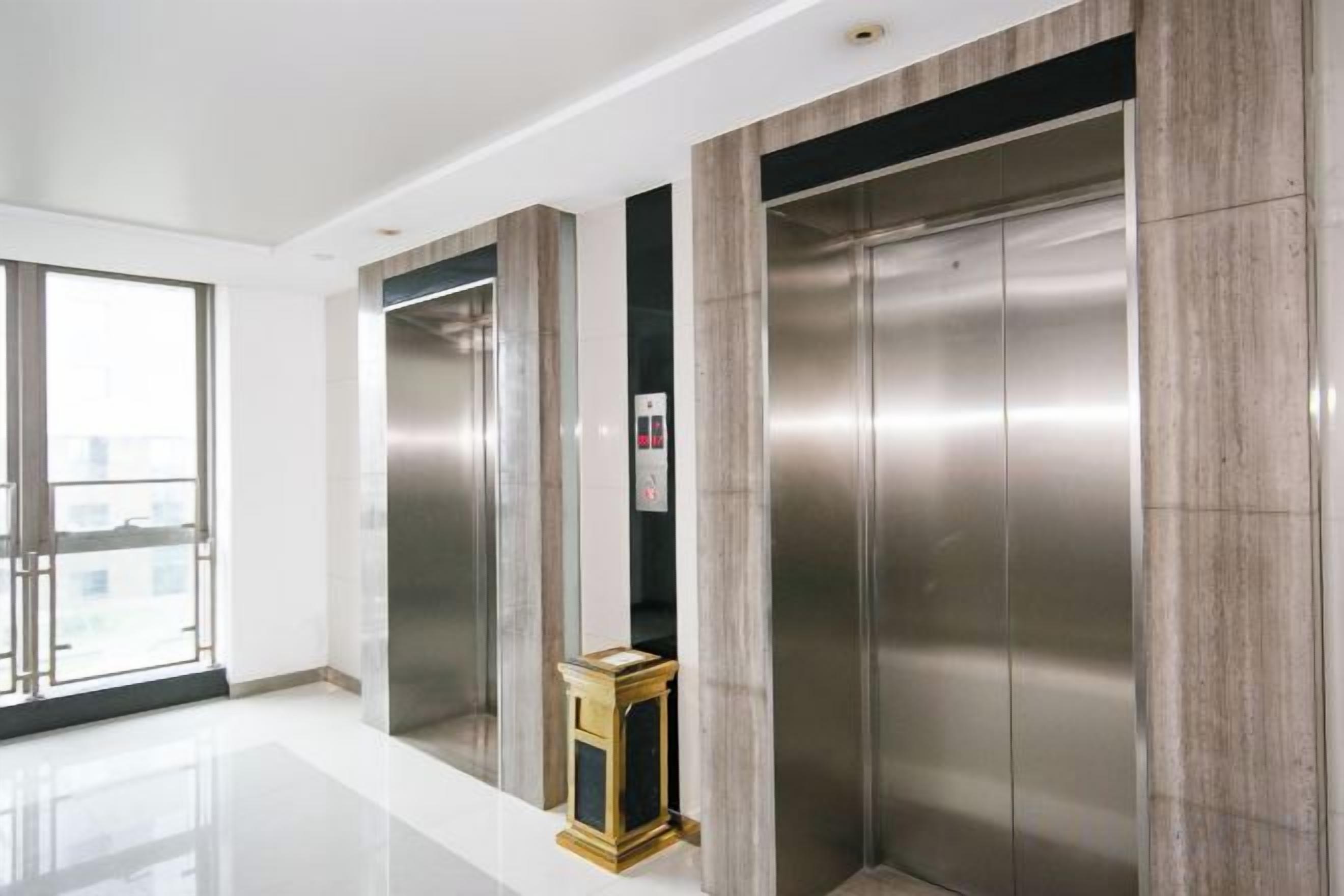 A modern elevator with metallic finish and a small control panel.