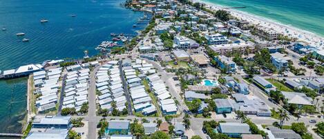 Vista aérea de una zona costera con puerto deportivo, playa y edificios residenciales.