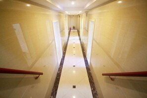 A long, narrow hallway with a central marble stripe, flanked by red handrails, leading to a distant point. - Weite Business Room (Penglai International Airport) (Yantai)