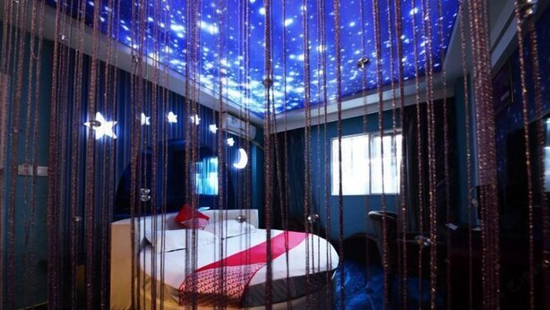 A room with a bed, star-shaped lights, and a ceiling with a starry design. - I Do Theme Hotel (Panjin)