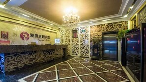 A hotel lobby with a marble floor, a reception desk, and decorative wall patterns. - I Do Theme Hotel (Panjin)
