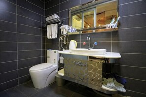 A bathroom with a toilet, sink, and mirror.