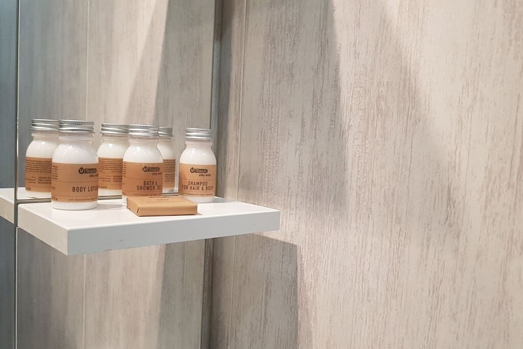 Ein Badezimmerschrank mit Körperlotion, Duschgel und Shampoo.