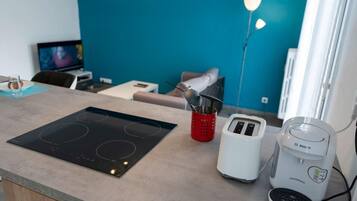 Une cuisine moderne équipée d’une plaque de cuisson à induction, d’un grille-pain et d’une machine à café.