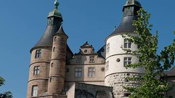 Un château historique doté de deux tours imposantes, d’une cour centrale et d’une tour ronde.