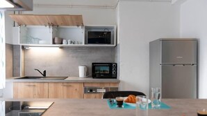 Een moderne keuken met houten kasten, een roestvrijstalen koelkast, een magnetron en een gootsteen.