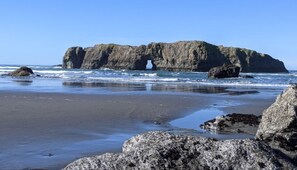 A rocky coastline with a prominent rock formation featuring a natural arch.