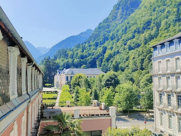 A building with a traditional architectural style, surrounded by lush greenery and mountains in the background. - Studio 2/4 ppl near Cauterets center (Cauterets)
