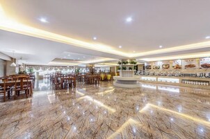 Un vestíbulo amplio con piso de mármol pulido, una zona de recepción central y diversas opciones de asientos.