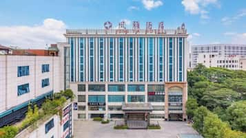 A hotel with a modern facade, multiple floors, and a prominent entrance.