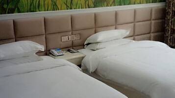 A hotel room with two beds, a headboard with a control panel, and a wall mural.