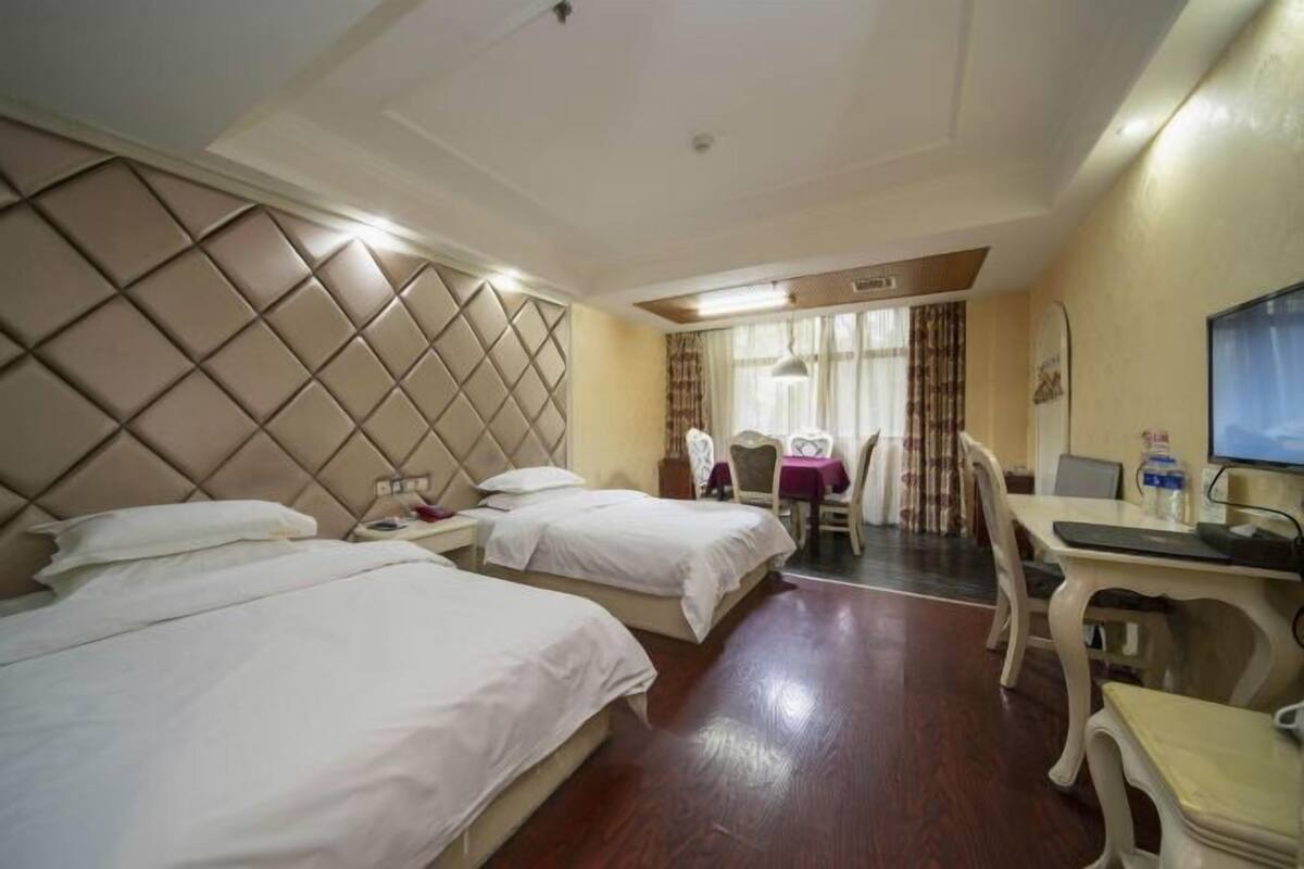 Een hotelkamer met twee bedden, een bureau en een stoel.