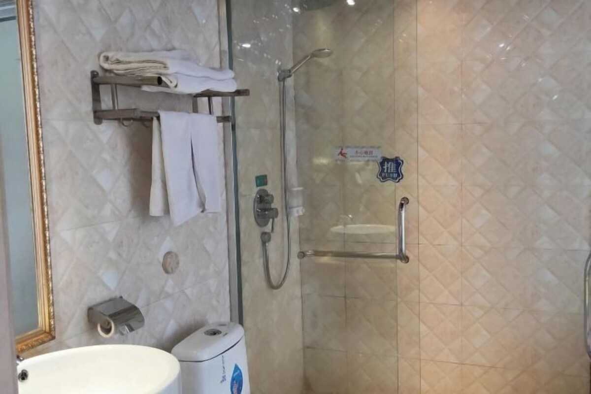 A bathroom with a toilet, sink, and glass-enclosed shower area.