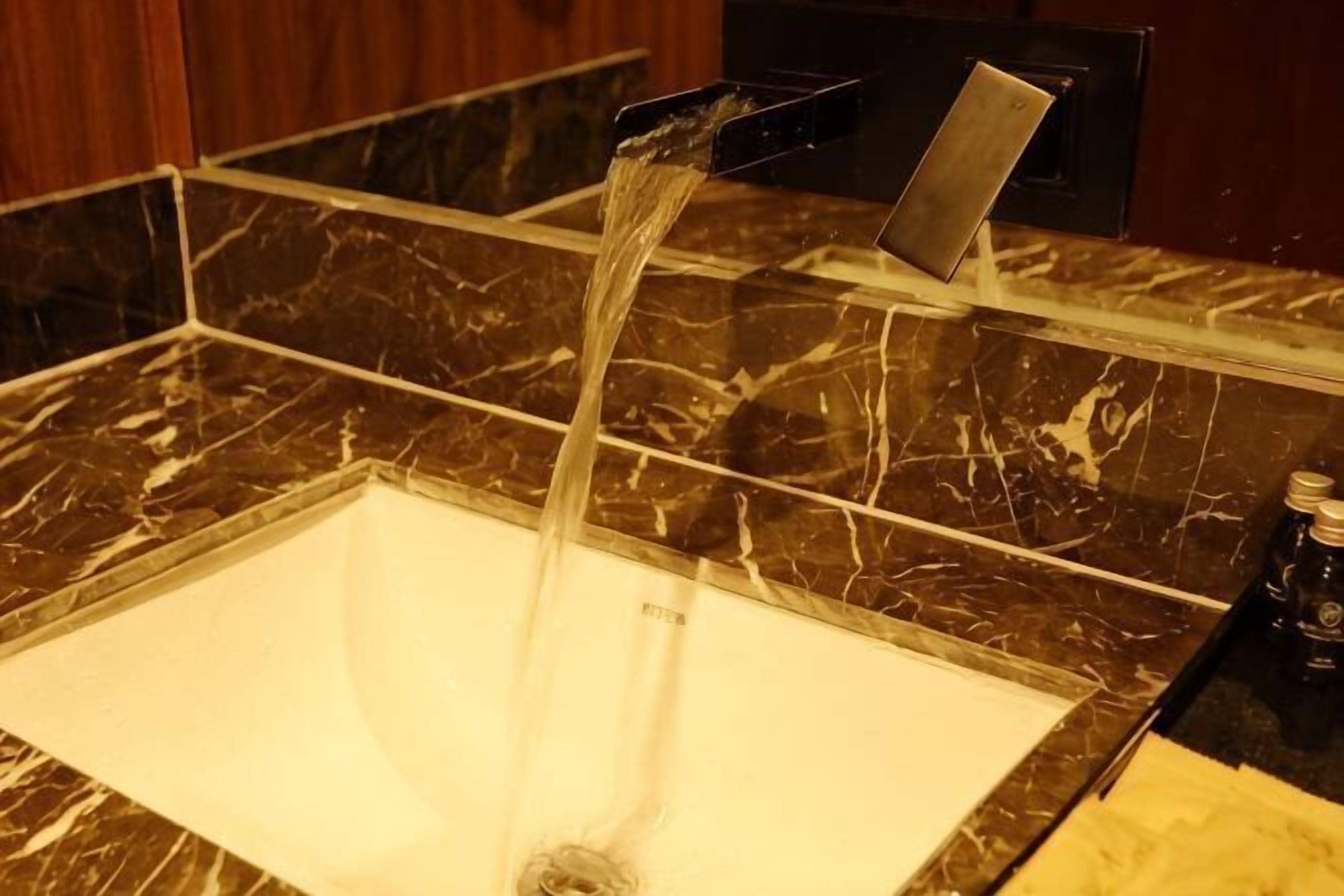 A bathroom with a marble sink and a faucet.