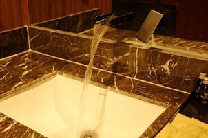 A bathroom with a marble sink and a faucet.