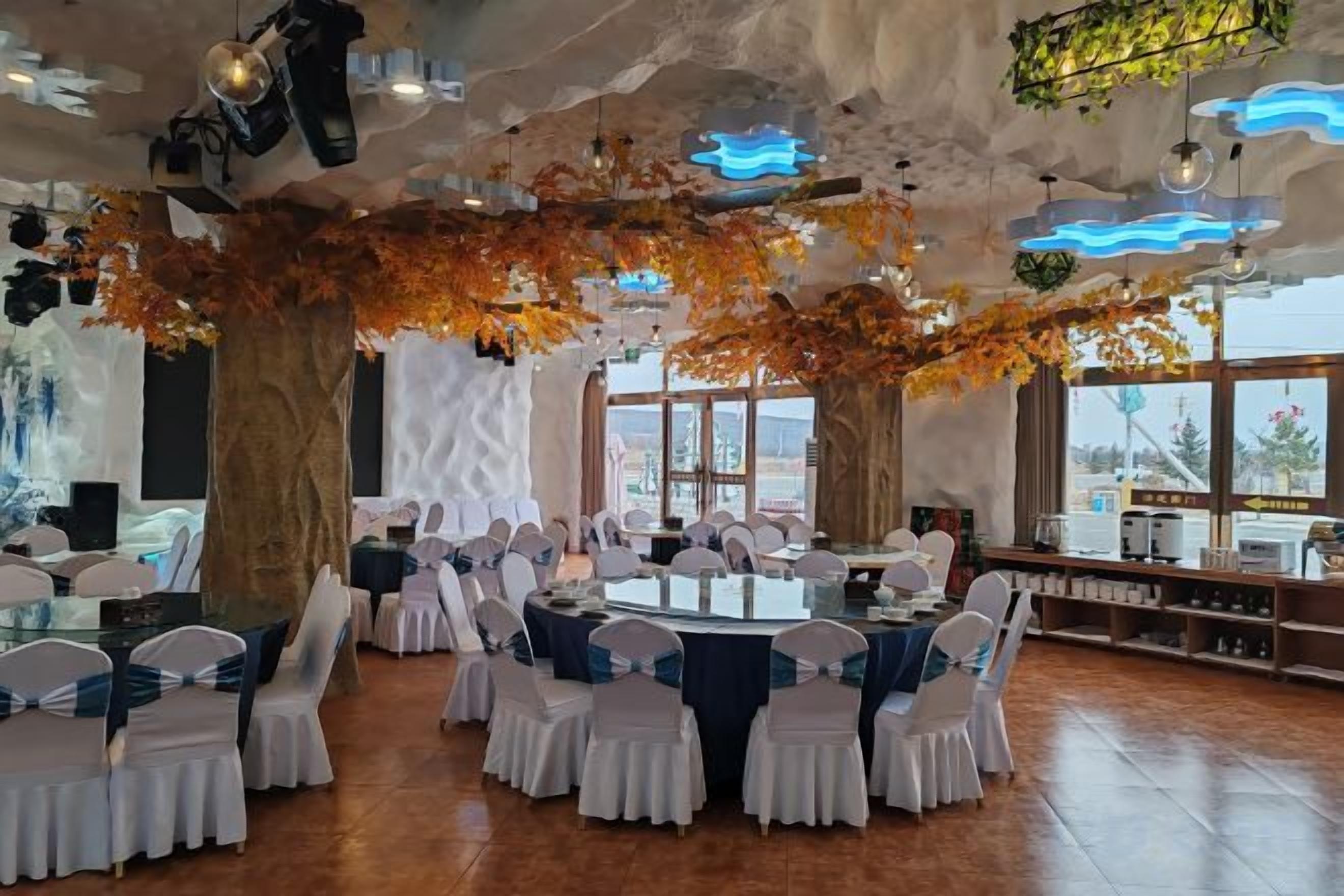 A restaurant with round tables, white chairs, and a view through large windows.