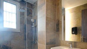A modern bathroom with a shower, toilet, and sink. - Falireon Hotel (Palaio Faliro)