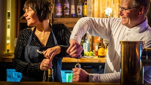 Un bar con un cantinero preparando una bebida.