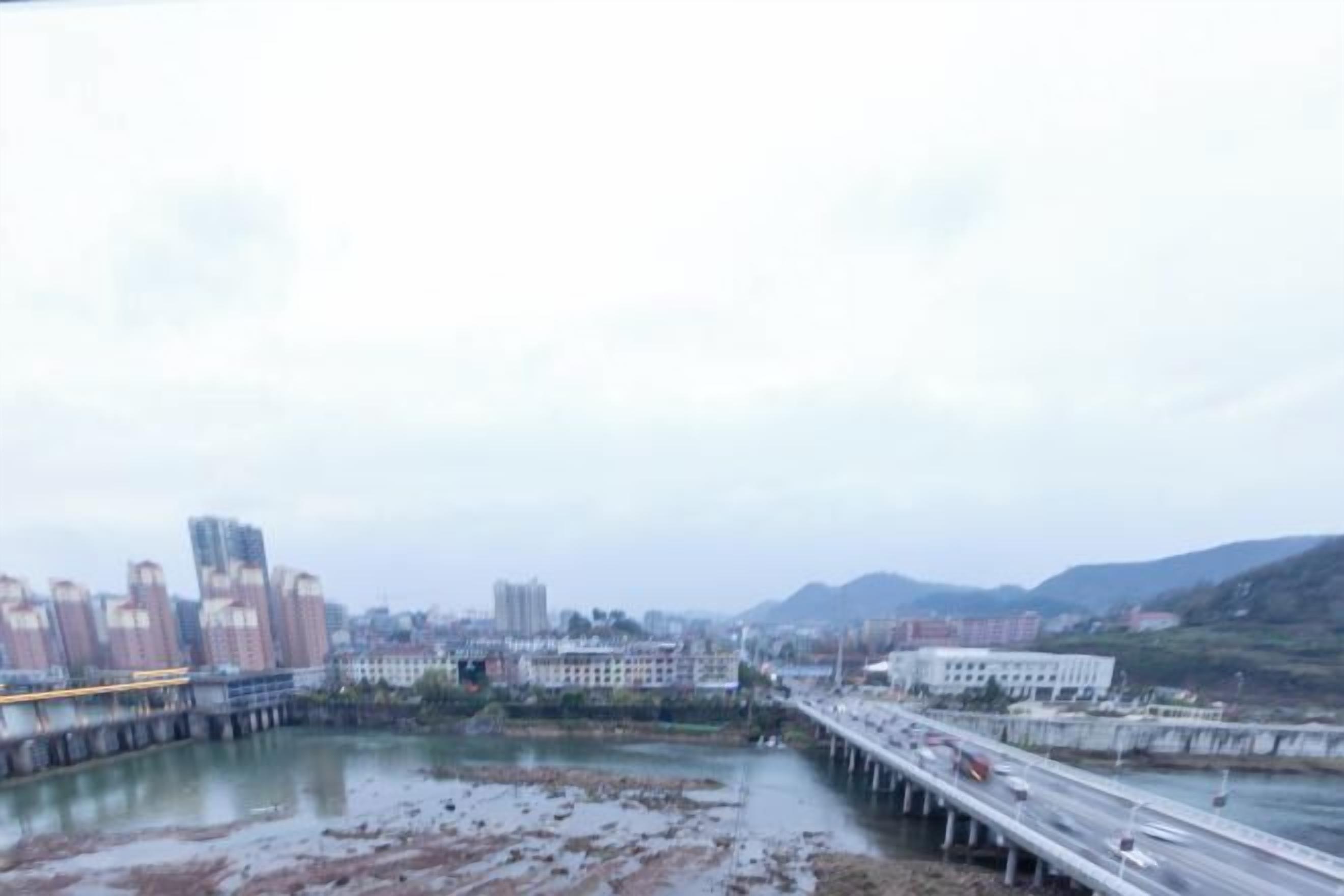 A river with a bridge and buildings in the background.