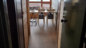 A narrow hallway leading to a dining area with a table and chairs. - Comfortable Apartment, Ski-in/Ski-out, Balcony, Wifi (Les Arcs 1800)