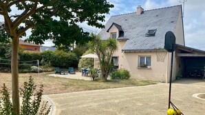 A house with a sloped roof, a tennis court, and a covered seating area. - Traditional house with garden and activities, quiet near the sea (La Baule)