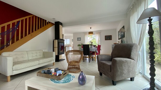 A living room with a sofa, armchair, coffee table, and a fireplace. - Traditional house with garden and activities, quiet near the sea (La Baule)