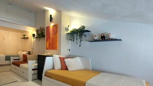 A modern bedroom with a bed, bedside tables, a wall-mounted shelf with decorative items, and a small plant. - Mezzanine Duplex 5 pers. · Ski-in/out · Mont Blanc View (Les Arcs 1800)