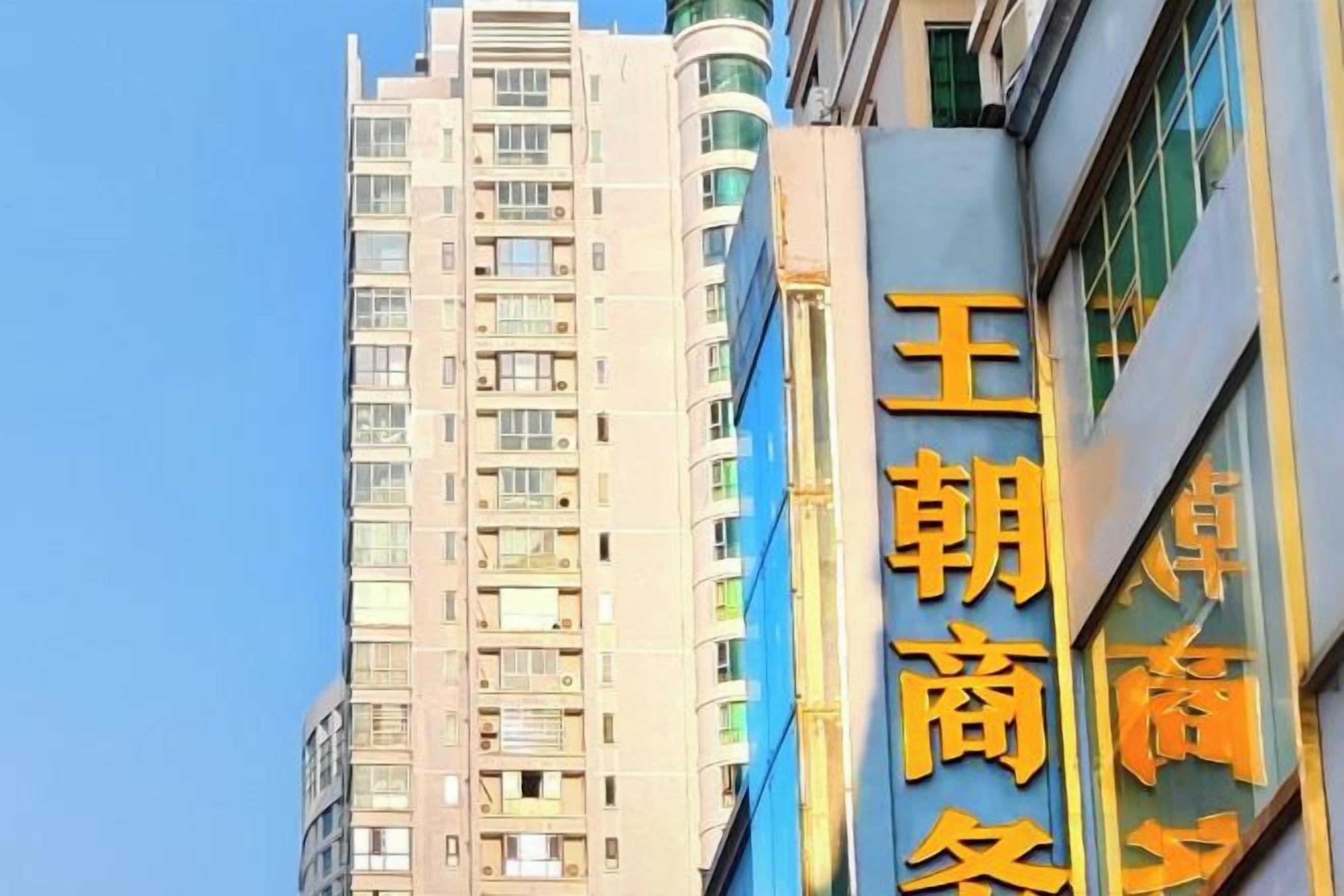 Un edificio de varios pisos con un cartel llamativo en la fachada.