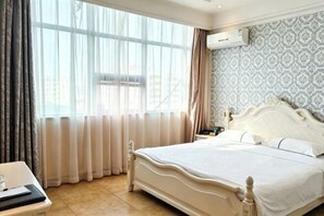 Een hotelkamer met een bed, gordijnen, een airconditioner en behang met een patroon.