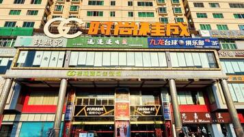 A multi-story building with various commercial establishments on the ground floor, including a fashion store and a restaurant.