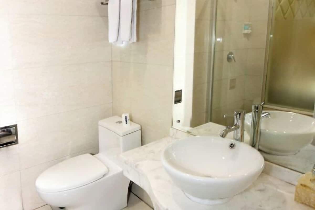 A bathroom with a toilet, a sink, and a glass shower enclosure.