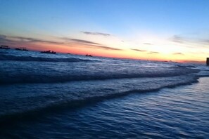 A beach scene with waves and a sunset. - Wangchao Business Hotel (Beihai)