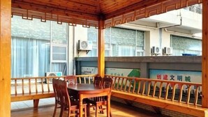 Habitación con paneles de madera, una mesa de comedor y sillas, ventanas grandes y unidades de aire acondicionado.