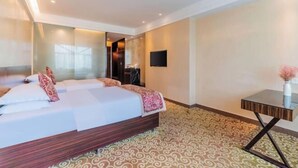 A hotel room with a large bed, a desk, a TV, and a patterned carpet. - Shenzhen Jiehao Business Hotel (Bao'an Airport Guyi Subway Station) (Shenzhen)