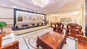 A hotel lobby with a reception desk, a chandelier, and traditional wooden furniture. - Shenzhen Jiehao Business Hotel (Bao'an Airport Guyi Subway Station) (Shenzhen)