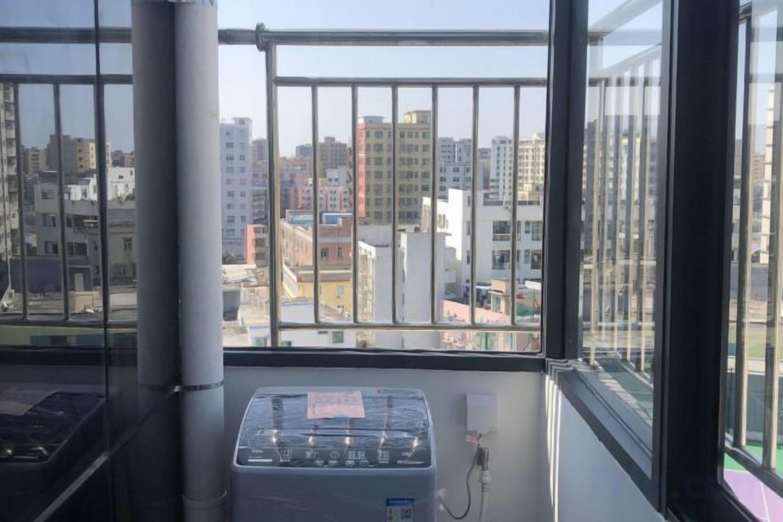 Una habitación con ventana que da a un paisaje urbano, un radiador y un enchufe.