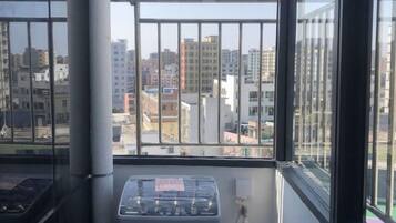 Una habitación con ventana que da a un paisaje urbano, un radiador y un enchufe.