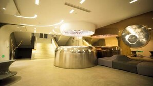 A modern interior with a central metallic structure, recessed lighting, and a circular wall feature. - Happy Air Hotel (Jiande) (Jiande)