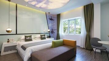 Una habitación de hotel moderna con cama, sofá, escritorio y ventana con cortinas.